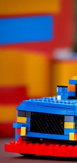 A colorful Lego racecar with a vibrant blue front against a blurred background.