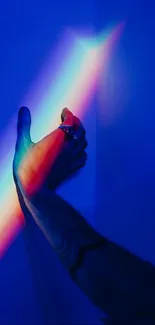 Hand interacting with rainbow light on blue background.