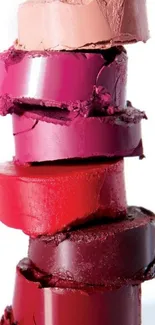 Vibrant red and pink lipstick stack displayed elegantly.