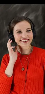 Smiling woman with headphones wearing a red sweater.