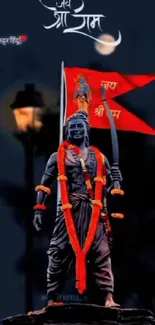 Lord Rama statue with red flag under moonlit sky.