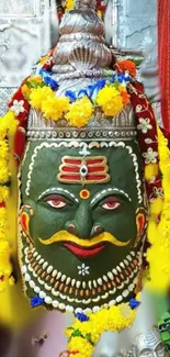 Brightly decorated Lord Shiva idol with flowers.