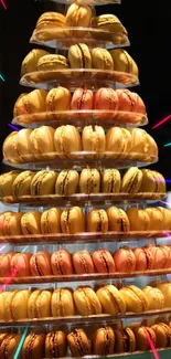 A tower of colorful macarons displayed elegantly with vibrant background lights.