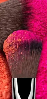 Colorful makeup brushes with pink and orange powder.