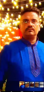 Man in blue kurta with festive lights background.