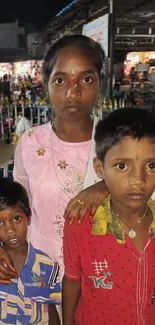 Family standing in a vibrant market setting at night.