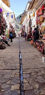 Colorful marketplace on cobblestone street with vibrant goods and bustling activity.