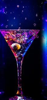 Vibrant martini glass with colorful splash on dark blue background.