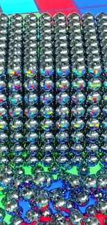 Reflective metal beads on colorful geometric background.