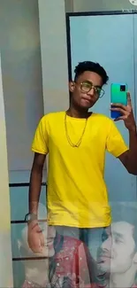 Stylish person in mirror taking a selfie wearing a bright yellow shirt.