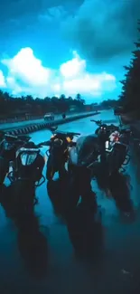 Five motorbikes on a wet highway under a vibrant blue sky.