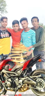 Group of friends with a red motorcycle in a vibrant outdoor setting.