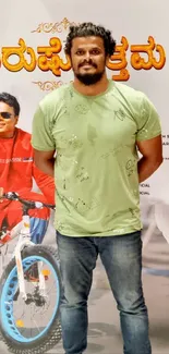 Figure in green shirt stands by colorful poster of motorcycle.