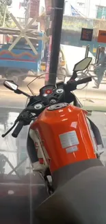 Vibrant orange motorcycle in a showroom with street view.