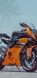 Orange and black motorcycle with tropical background