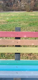 Multicolor park bench with a vibrant landscape background.