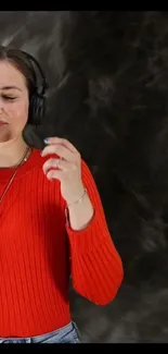 Woman in orange sweater enjoying music with headphones in an artistic background.