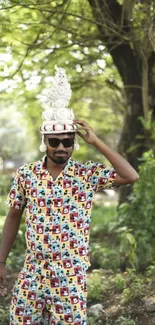 Man in colorful attire under a leafy tree.