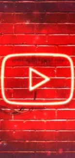 Neon play button glowing on red brick wall.