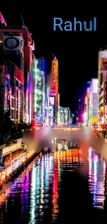 Vibrant neon cityscape wallpaper with colorful reflections on the water at night.