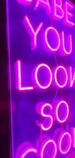 Neon sign reading 'Babe you look so cool' against a purple backdrop.