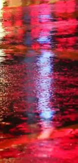 Neon street reflection with red hues on wet pavement.