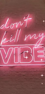 Neon 'Don't Kill My Vibe' sign on brick wall, vibrant pink.