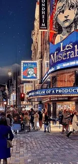 City street with Les Misérables theater poster at night.