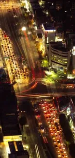 Aerial view of a vibrant city intersection at night with illuminated streets.