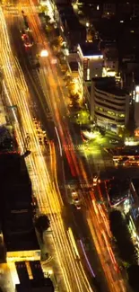 Aerial view of a vibrant city street lit up at night, featuring bustling traffic.