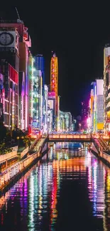 Vibrant cityscape at night with colorful reflections on a river.