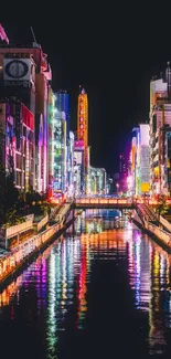 Colorful cityscape at night reflecting on water.