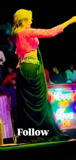 Energetic dance performer on vibrant stage at night.