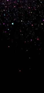 Colorful specks on a black night sky wallpaper, perfect for mobile.