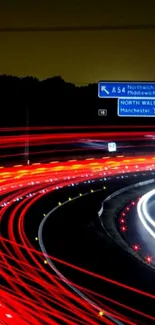 Long exposure photo of night highway with vibrant red light trails.