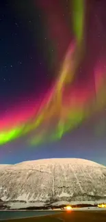 Colorful northern lights over snow-covered mountain.