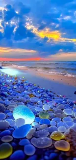 Colorful pebbles on the beach with a vibrant sunset over the ocean.