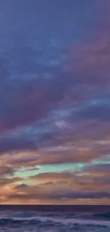 Sunset over ocean with vibrant clouds and waves.