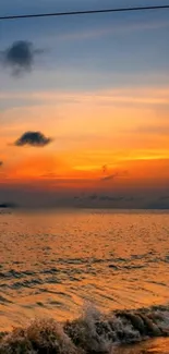 Calming ocean sunset with golden sky and gentle waves.