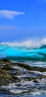 A vibrant ocean wave crashing on rocks under a clear blue sky.