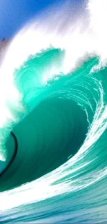 Vibrant teal ocean wave crashing under a clear blue sky.