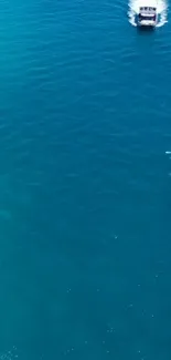 Turquoise ocean with boat creating white waves.