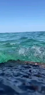 Dynamic ocean waves against a clear blue sky.