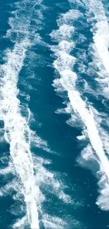 Aerial view of dynamic white ocean wakes on deep blue water.