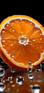 Close-up of an orange slice on a black backdrop with water droplets.