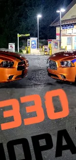 Orange Dodge Chargers at night in a gas station with notable '330 MOPAR' text.