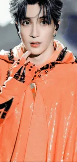 Person in vibrant orange hoodie with detailed patterns.