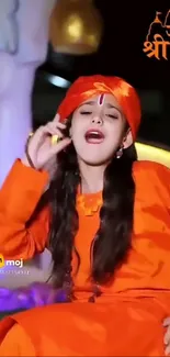 Girl in vibrant orange traditional attire with festive theme.