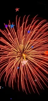 Explosive orange firework on black night sky.