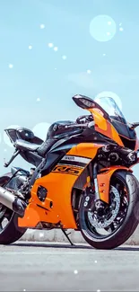 Vibrant orange sport motorcycle parked on an open road.